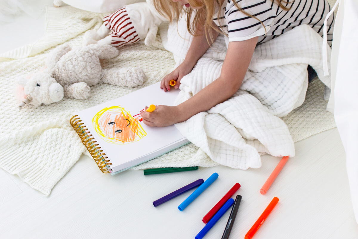 Ways to declutter your kid’s room - girl drawing with markers