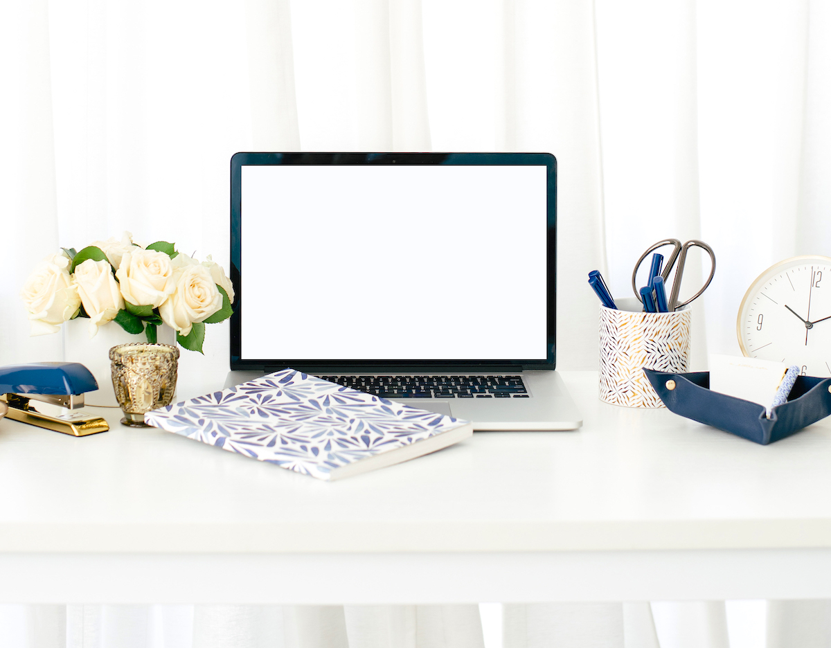 Freelance services at Love from Lisa blog - laptop on desk with flowers, stationery and clock.