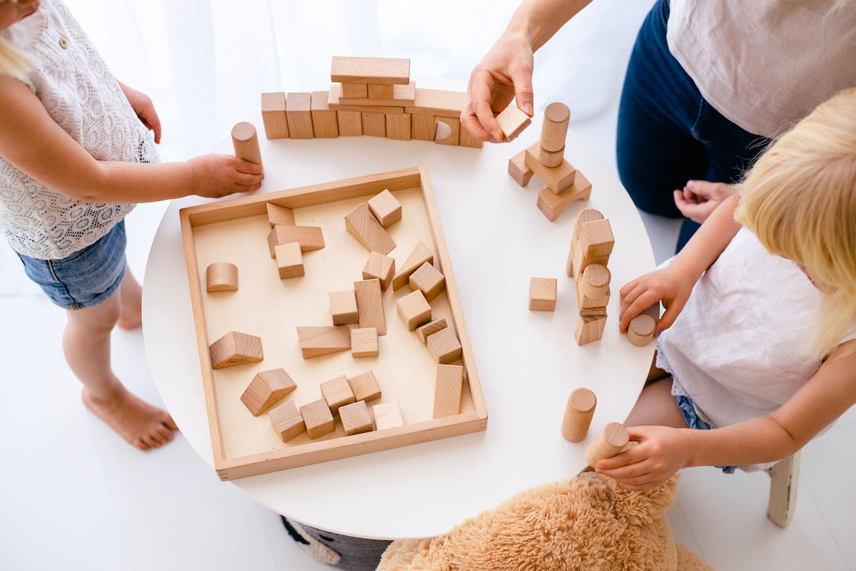 How to set boundaries for kids - 2 girls and a mum sitting around a table playing blocks.