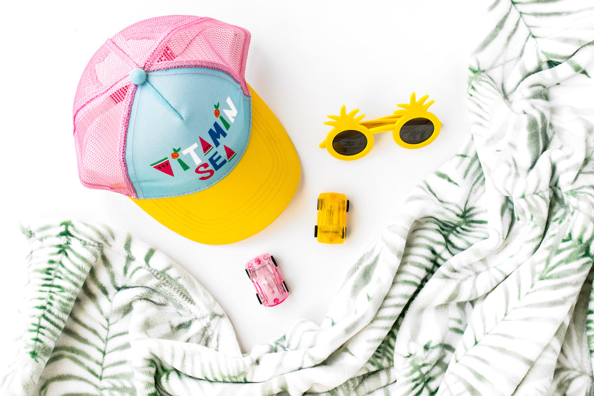 Ultimate guide to keeping your kids engaged all summer - kids summer hat, yellow sunglasses, cars, and blanket.