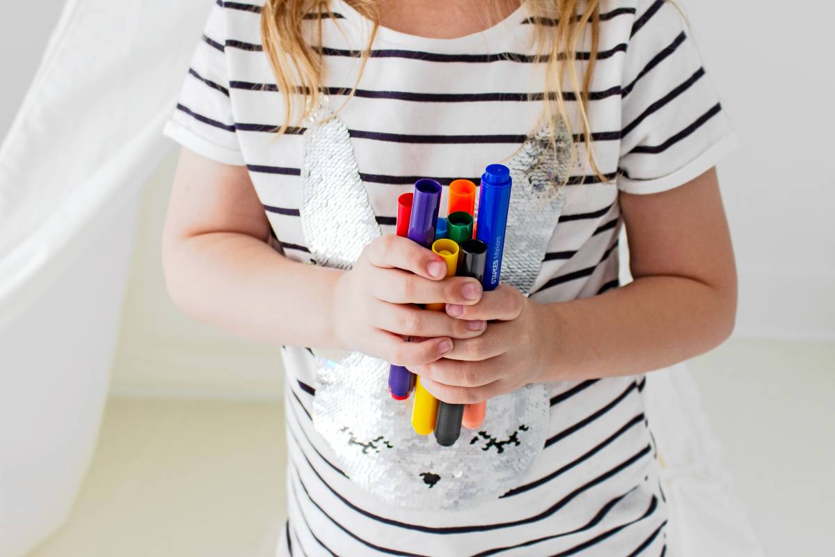 What is mum guilt and how to overcome it - girl holding markers.