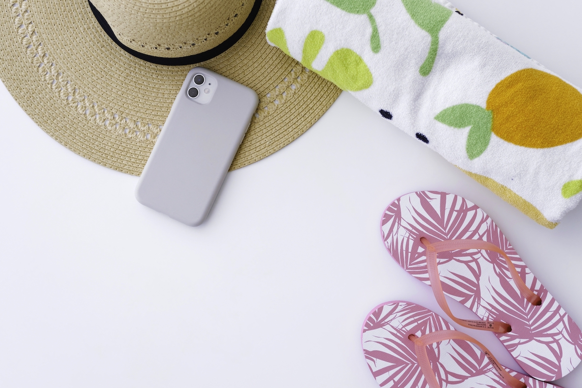 How to travel with kids - hat, phone, towel and flip flops.