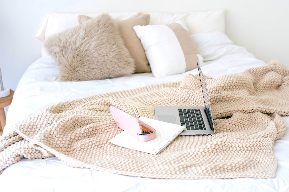 Strategies for working mums to overcome mum burnout - bed with laptop and notebook.