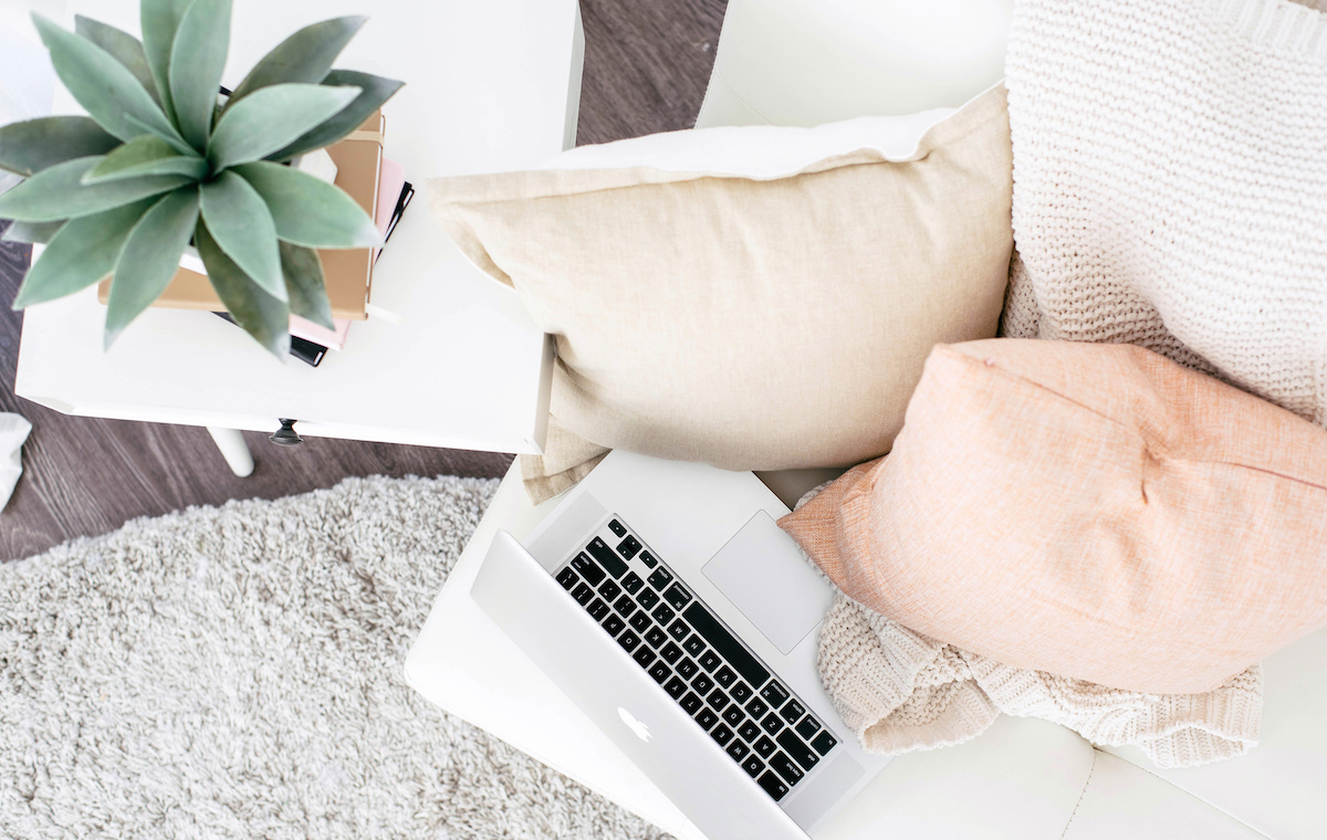 What is home insurance - couch with laptop, cushions and plant.