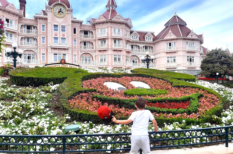 Large pink hotel with boy standing out the front - one of the things to see when visiting Disneyland Paris in one day.