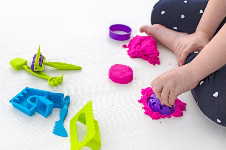 Young girl playing with Play-Doh - one of the things kids can do at home.