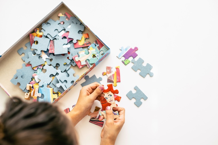 Young child doing a puzzle - one of the things kids can do at home.