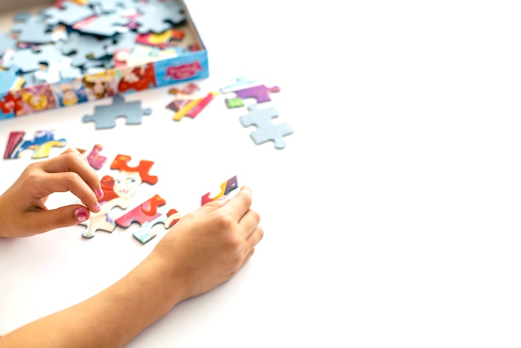 Kid doing a puzzle - one of the things you can buy to prepare for school holidays.