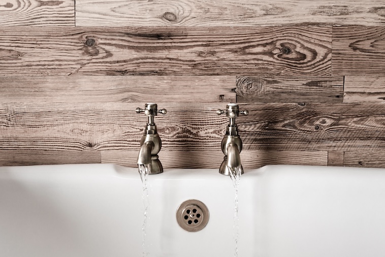 Taps running over a bath - one way to style your home using interior design tips.