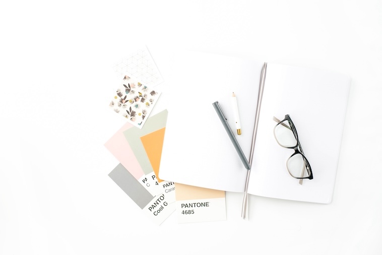 5 Pantone colour cutouts, 2 pens, notepad, glasses - things you need in the design process of building a family home.