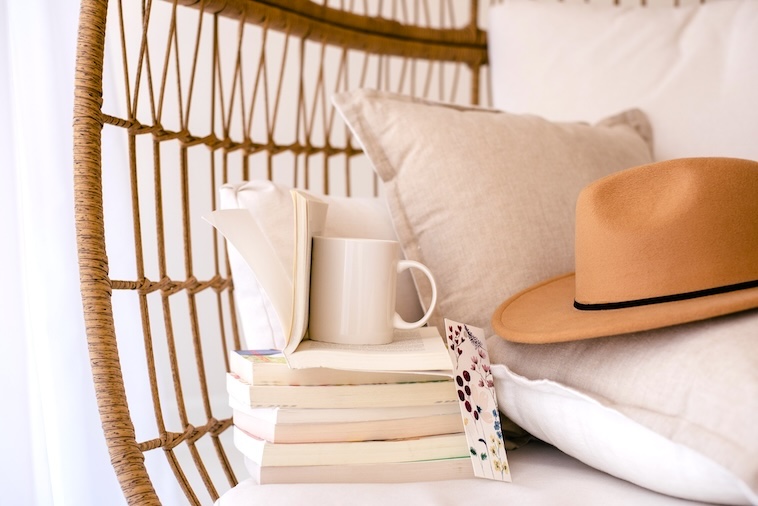 Book, tea, hat on a couch - items you can use when finding time for yourself.