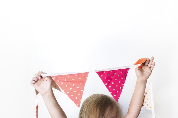 Child holding a spotty garland - organising decorations is one of the top event planning time saving tips.