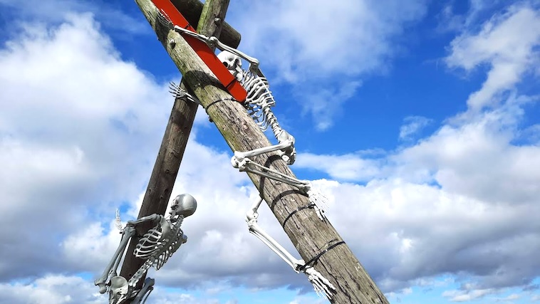 Skeletons climbing a post - decorating for Hallowee is one of many great family Halloween traditions.