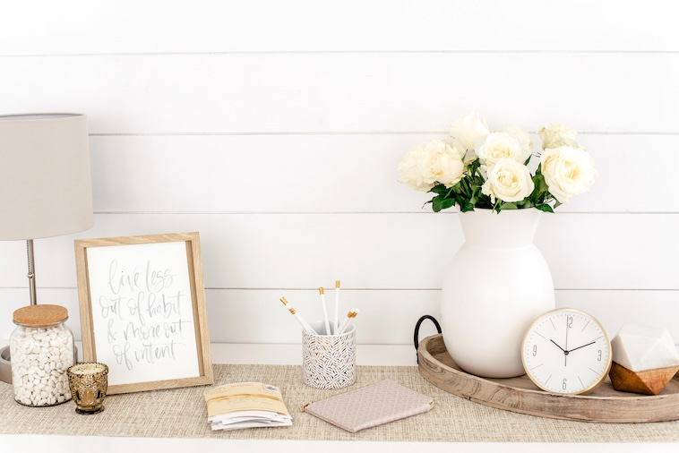 Lamp, vase with white roses, clock, table decor - things you can remove when you want to simplify your home.