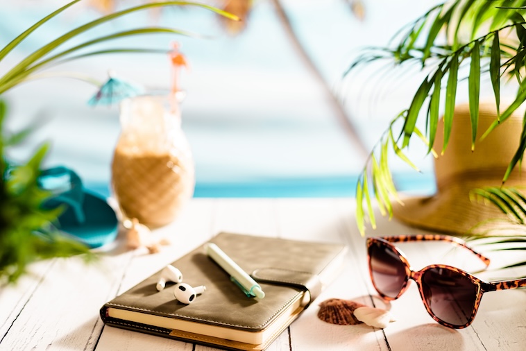 Notebook, sunglasses, ear pods, summer drink - things to remember when doing beach vacation prep.