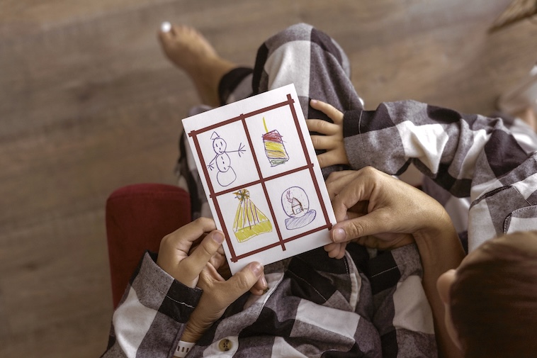 Boy holding Christmas drawing - things to do to prepare for Christmas early.