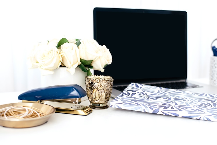 Laptop, stationery, flowers - things to use when writing word of the year ideas.