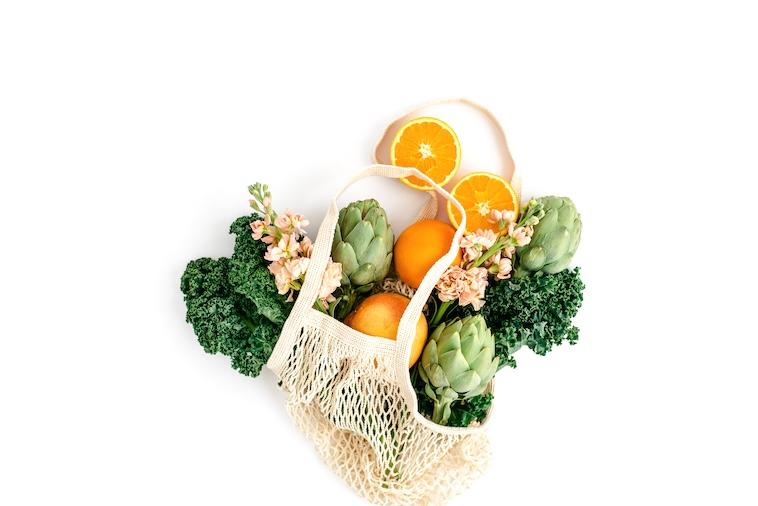 Fruit and vegetables in a woven bag - what to consider when looking at fridge organisation ideas.