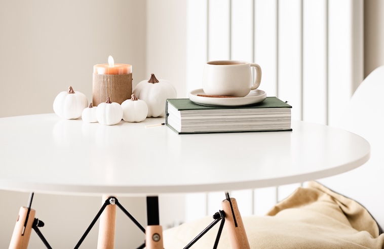 Table with candle, pumpkin ornaments, cup of tea - an eco-friendly family room.