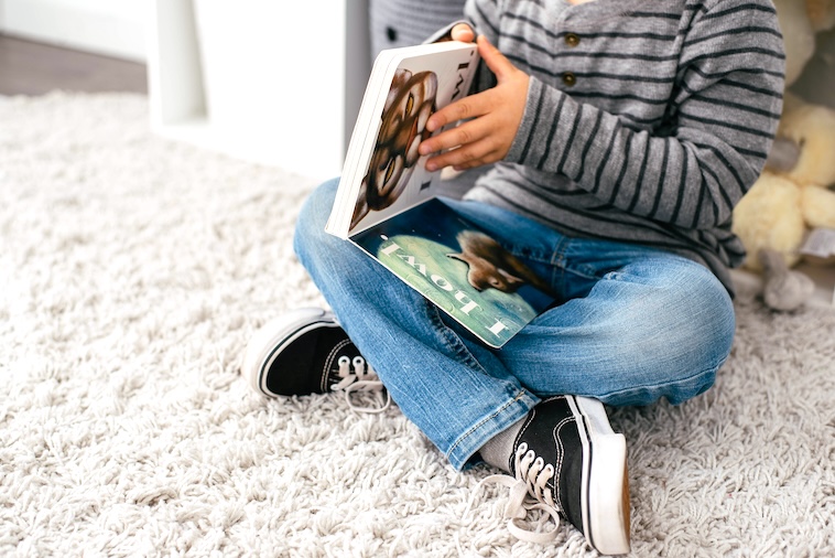 Boy reading book - family goals can include reading together as a family.