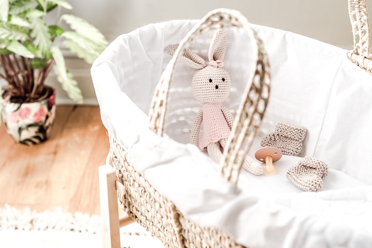 Baby moses basket with a toy bunny inside - how your baby sleeps is one of the parenting worries to let go off.