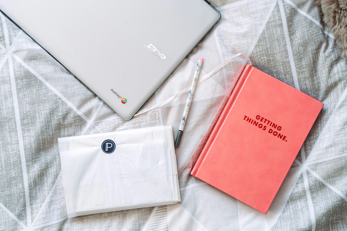 5 productivity tips for busy mums laptop and book on bed