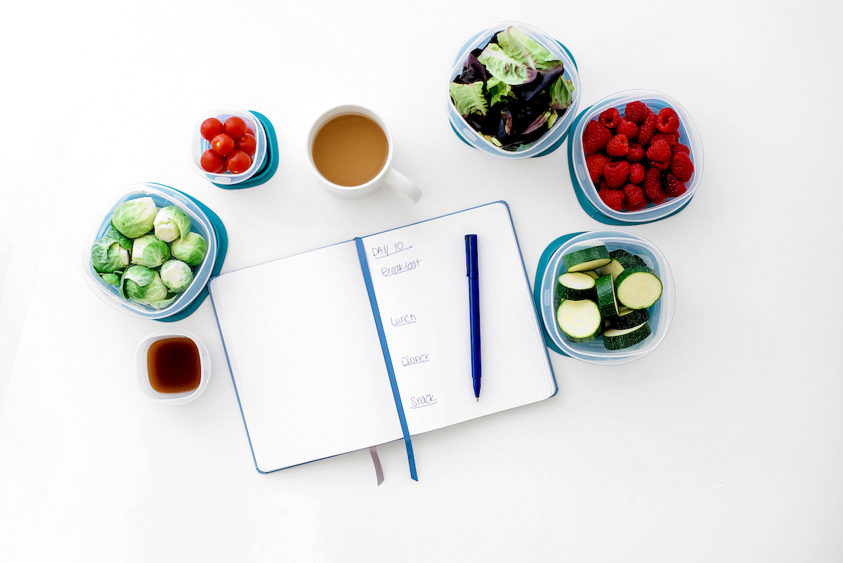 10 family meal planning tips - fruit and vegetables, tea, planner on table.