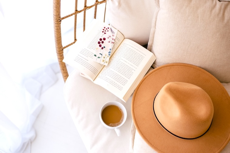 Book, tea, hat on a couch - items you can use when finding time for yourself.