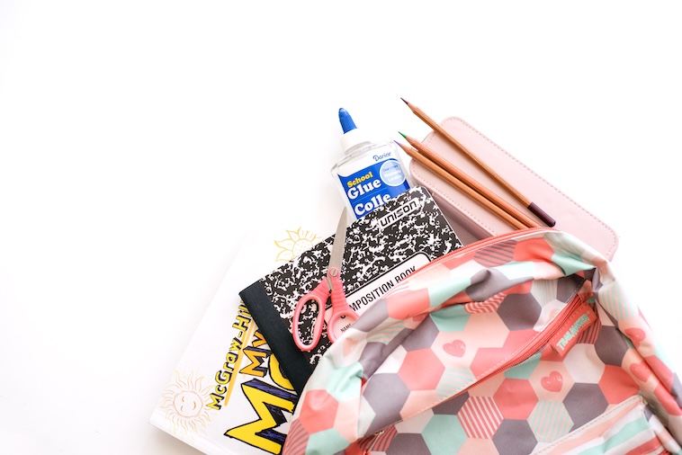 School bag with books, glue, pencils, scissors - school supplies you can buy when making school traditions.