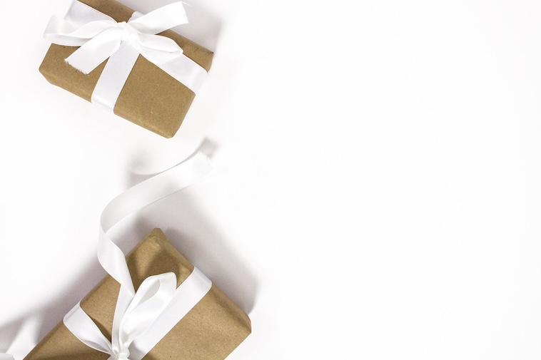 2 gifts wrapped in brown paper with white ribbons - a guide that makes choosing the perfect gift easier.