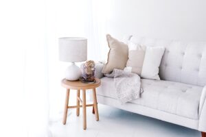 Sofa, side table with lamp and decor - practical home upgrades to make to living rooms.