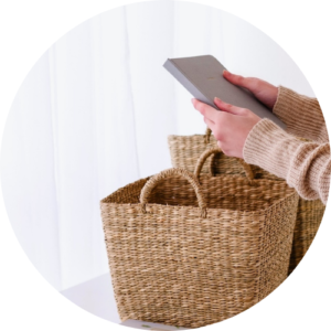 Woman putting book into woven basket - an organisation and productivity tips for mums.