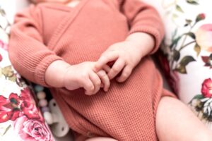 Baby in a pink onesie - a guide to baby essentials.